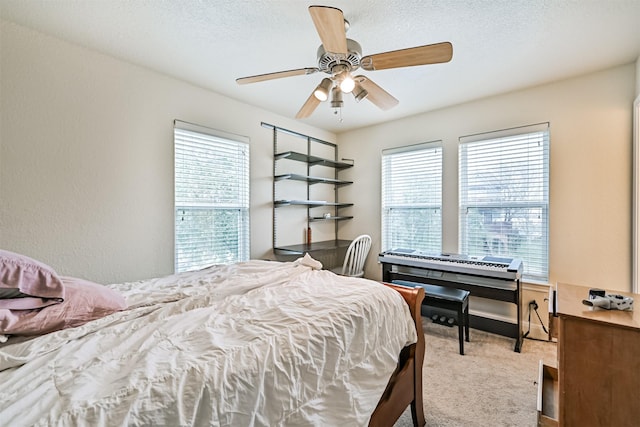 bedroom with carpet, ceiling fan, and a textured ceiling