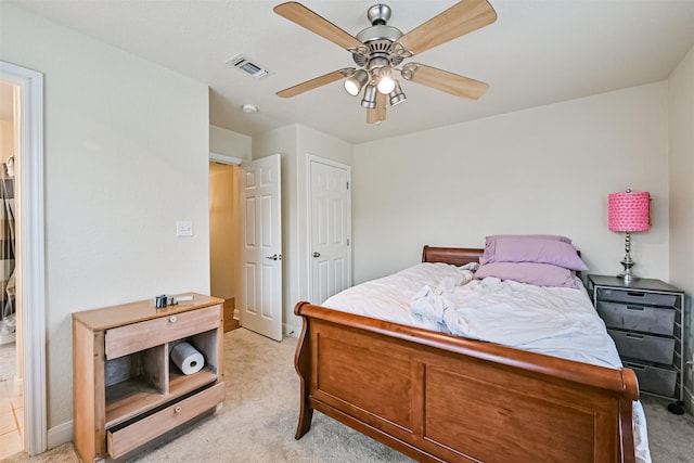 bedroom featuring visible vents, light colored carpet, and a ceiling fan