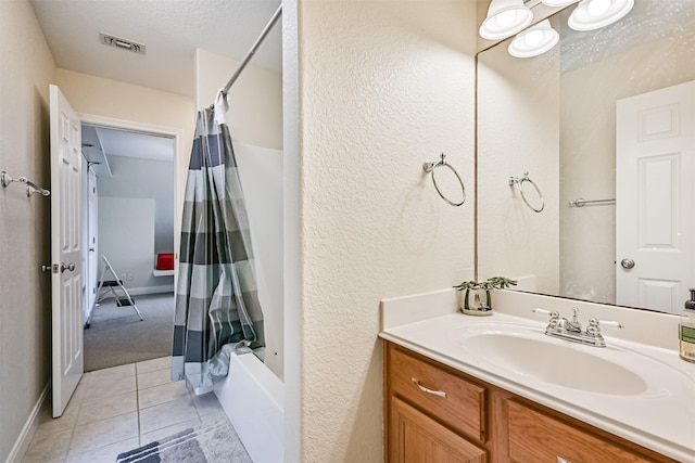 bathroom with visible vents, shower / tub combo with curtain, a textured ceiling, tile patterned flooring, and vanity