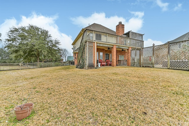 rear view of house featuring a ceiling fan, a fenced backyard, a chimney, a lawn, and brick siding