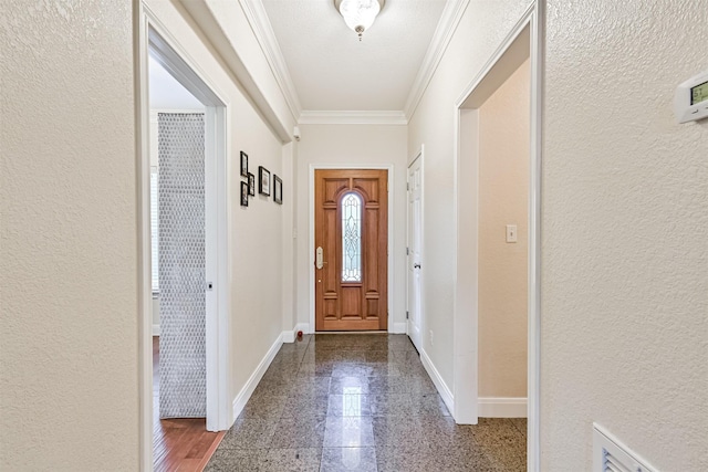 foyer with crown molding, granite finish floor, a textured wall, and baseboards