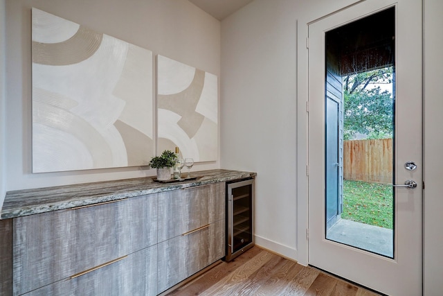 doorway to outside with beverage cooler and light wood-type flooring