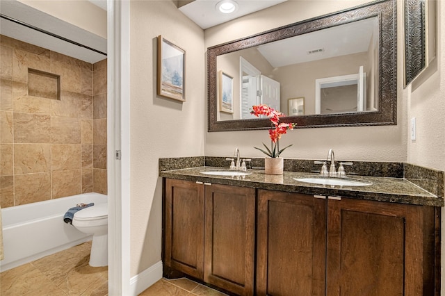 full bathroom featuring tiled shower / bath, vanity, and toilet