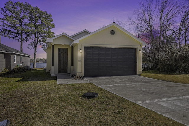 view of front of home featuring a garage, a water view, a yard, and central air condition unit