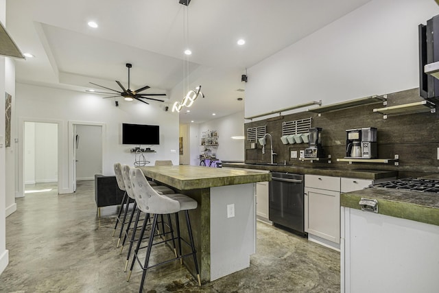 kitchen featuring a kitchen bar, white cabinetry, dishwasher, a kitchen island, and backsplash