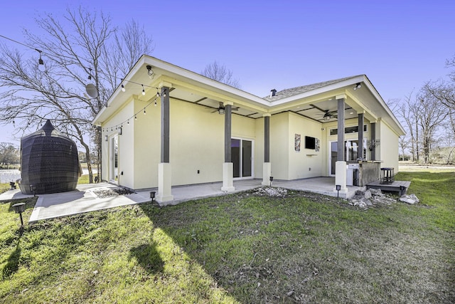 rear view of property featuring a patio, a yard, and ceiling fan