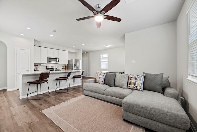 living room with ceiling fan and light wood-type flooring