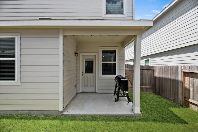 doorway to property with a lawn and a patio