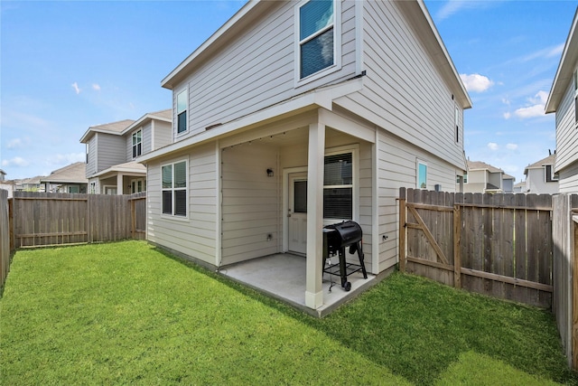 back of house with a patio and a yard