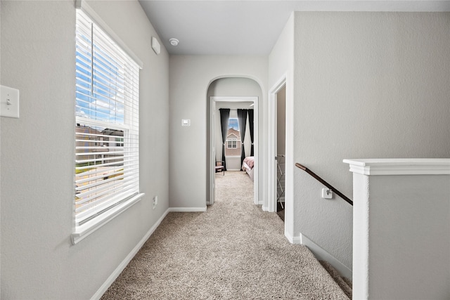 hallway with light carpet and a healthy amount of sunlight