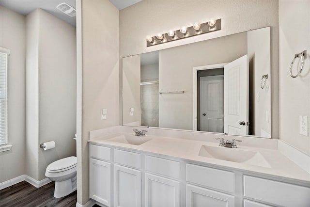 bathroom featuring walk in shower, wood-type flooring, vanity, and toilet