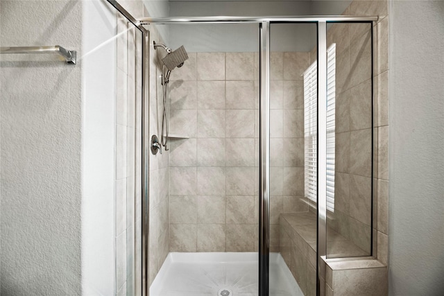 bathroom with a shower with door