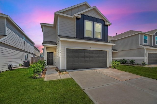 view of front of house with a garage, central air condition unit, and a lawn