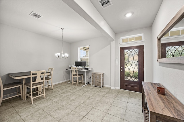 tiled foyer featuring an inviting chandelier