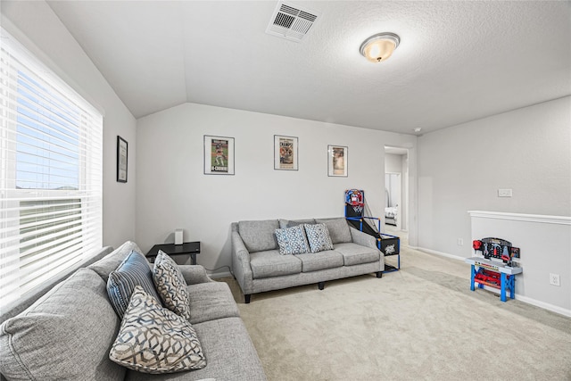 carpeted living room featuring lofted ceiling and a textured ceiling