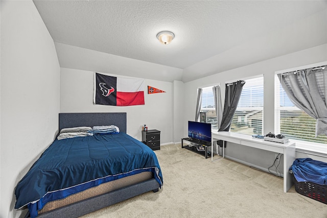 bedroom with vaulted ceiling, carpet, and a textured ceiling