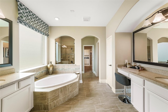 bathroom with vanity and shower with separate bathtub