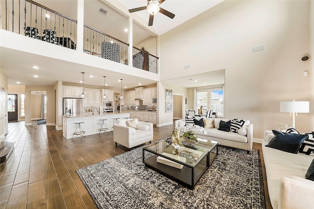 living room featuring a high ceiling and ceiling fan