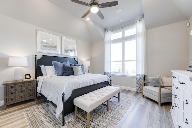 bedroom with ceiling fan, vaulted ceiling, and light wood-type flooring