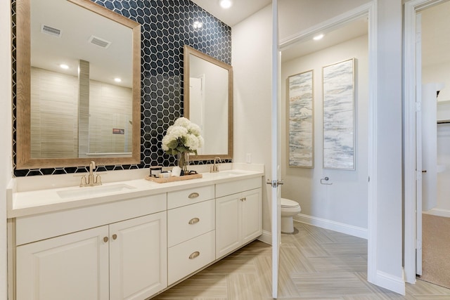 bathroom featuring parquet flooring, vanity, and toilet