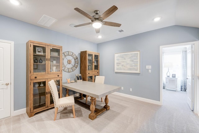 dining area featuring lofted ceiling, light carpet, and ceiling fan