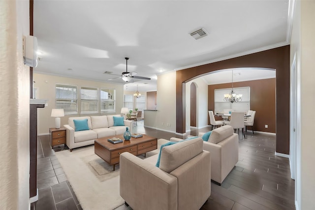 living room featuring ceiling fan with notable chandelier, ornamental molding, and wood-type flooring