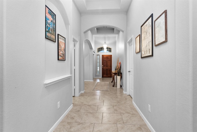 corridor with a towering ceiling and light tile patterned floors