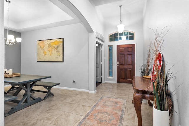 entryway featuring a tray ceiling and a chandelier