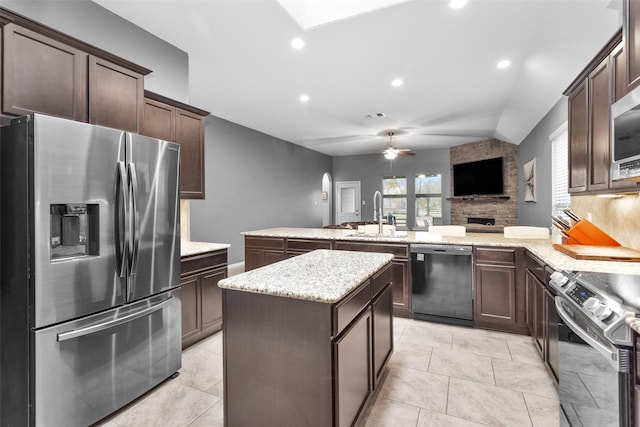 kitchen with a kitchen island, appliances with stainless steel finishes, sink, ceiling fan, and kitchen peninsula