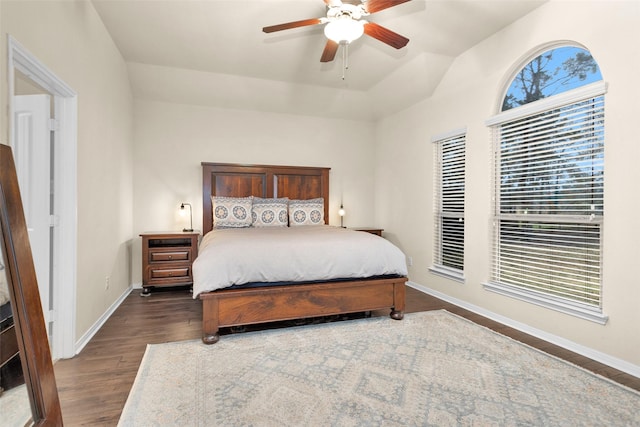 bedroom featuring ceiling fan, lofted ceiling, dark hardwood / wood-style flooring, and multiple windows