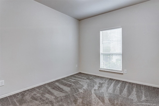 unfurnished room with dark carpet