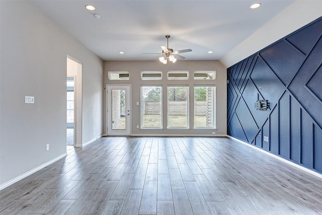 unfurnished living room with wood-type flooring and ceiling fan