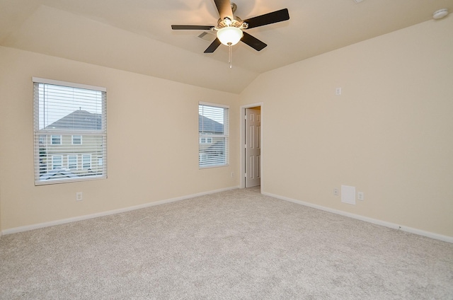 carpeted empty room with vaulted ceiling and ceiling fan