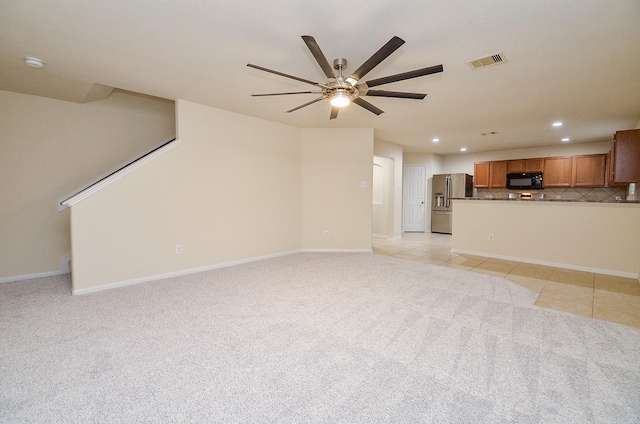 unfurnished living room featuring ceiling fan and light tile patterned floors