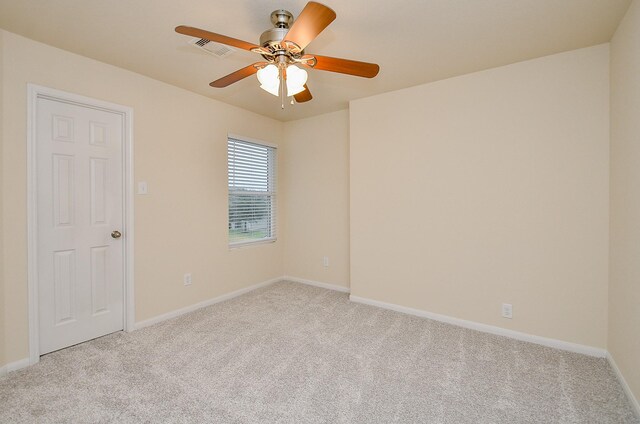 carpeted spare room with ceiling fan