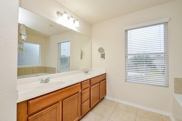 bathroom featuring tile patterned floors, a bathtub, vanity, and a wealth of natural light