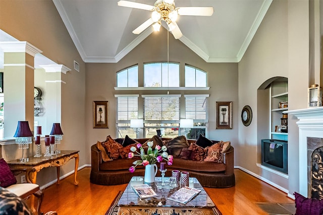 living room featuring hardwood / wood-style flooring, crown molding, built in features, and ceiling fan