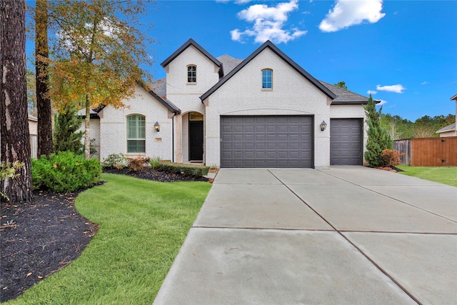 french country style house featuring a garage and a front yard