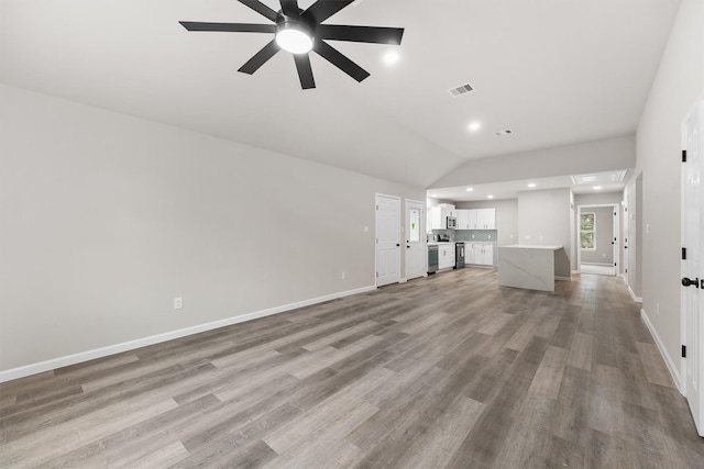 unfurnished living room featuring vaulted ceiling, ceiling fan, and light wood-type flooring