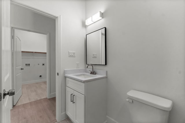 bathroom with hardwood / wood-style flooring, vanity, and toilet