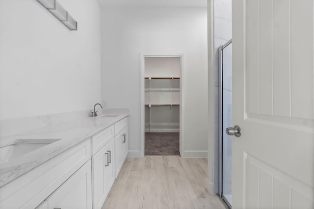 bathroom featuring walk in shower, vanity, and hardwood / wood-style floors