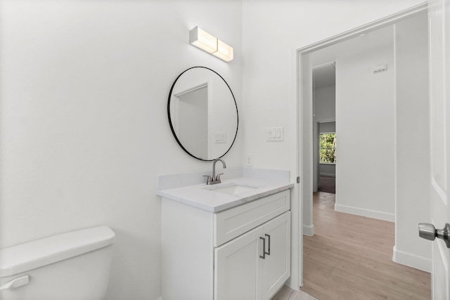 bathroom featuring vanity, hardwood / wood-style flooring, and toilet