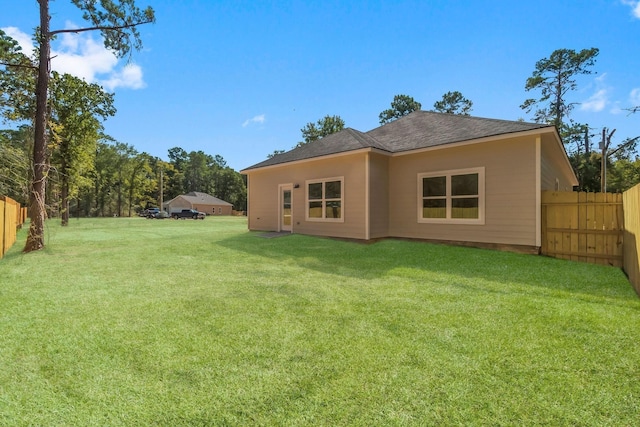 rear view of house featuring a lawn