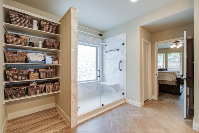 bathroom with a shower with shower door and ceiling fan