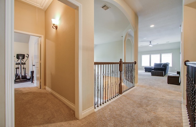 hall featuring carpet floors, attic access, visible vents, and baseboards