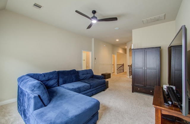 living room with baseboards, visible vents, vaulted ceiling, and light colored carpet