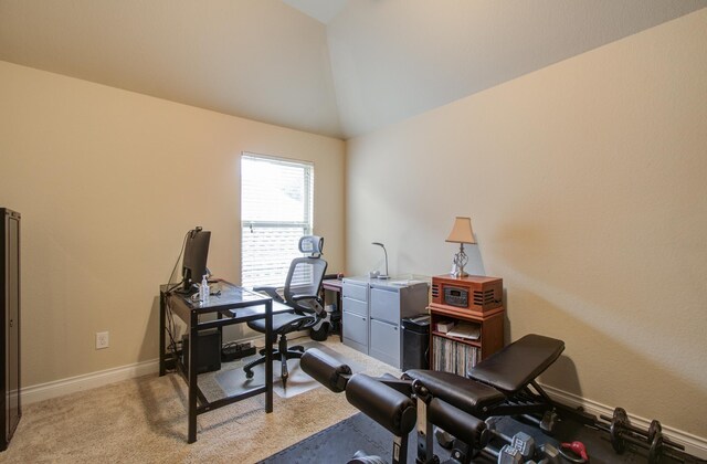 carpeted home office featuring lofted ceiling