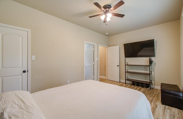 bedroom featuring a ceiling fan, baseboards, and wood finished floors