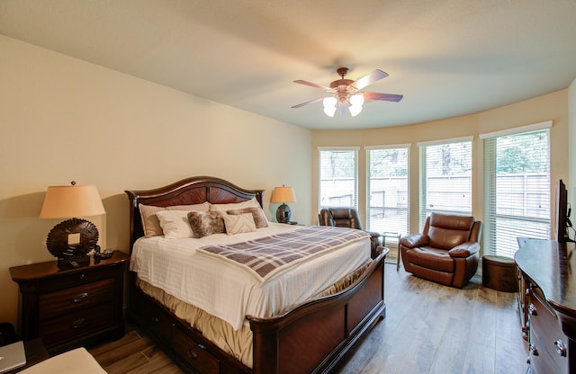 bedroom featuring hardwood / wood-style flooring, ceiling fan, and multiple windows