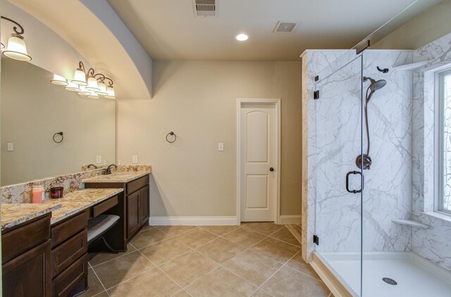 bathroom featuring vanity, a shower with shower door, tile patterned flooring, and a wealth of natural light